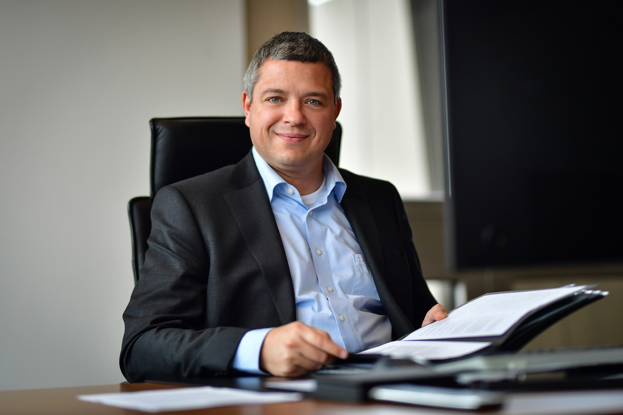 Marcus Wittig, Vorsitzender der DVV-Geschäftsführung, sitzt im Büro und blickt in die Kamera.