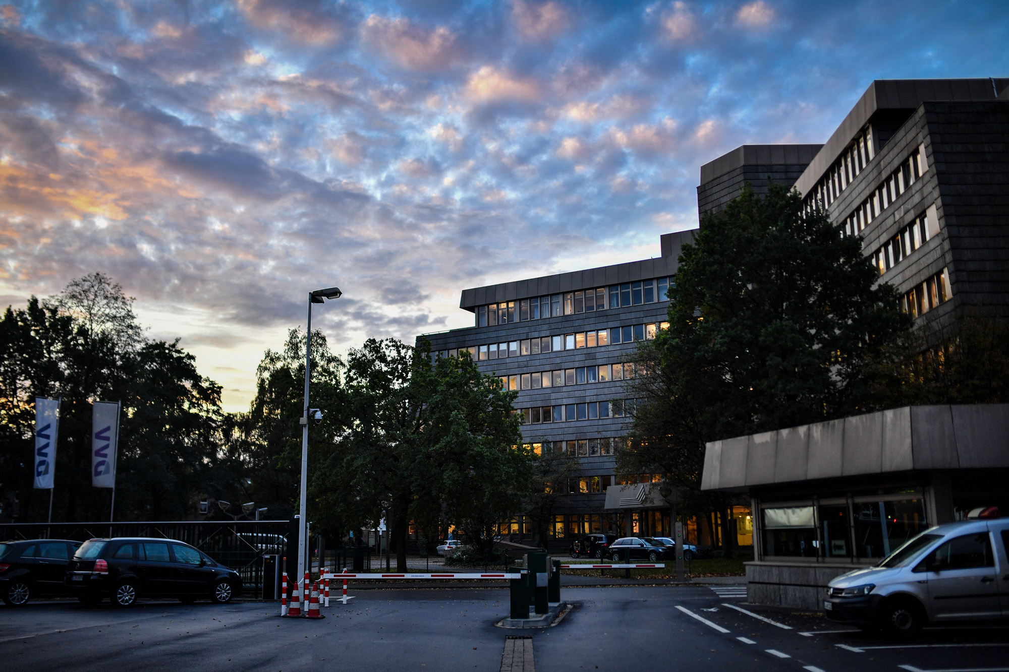 Die Konzernzentrale der DVV am Abend mit beleuchteten Fenstern und dramatischem Himmel.