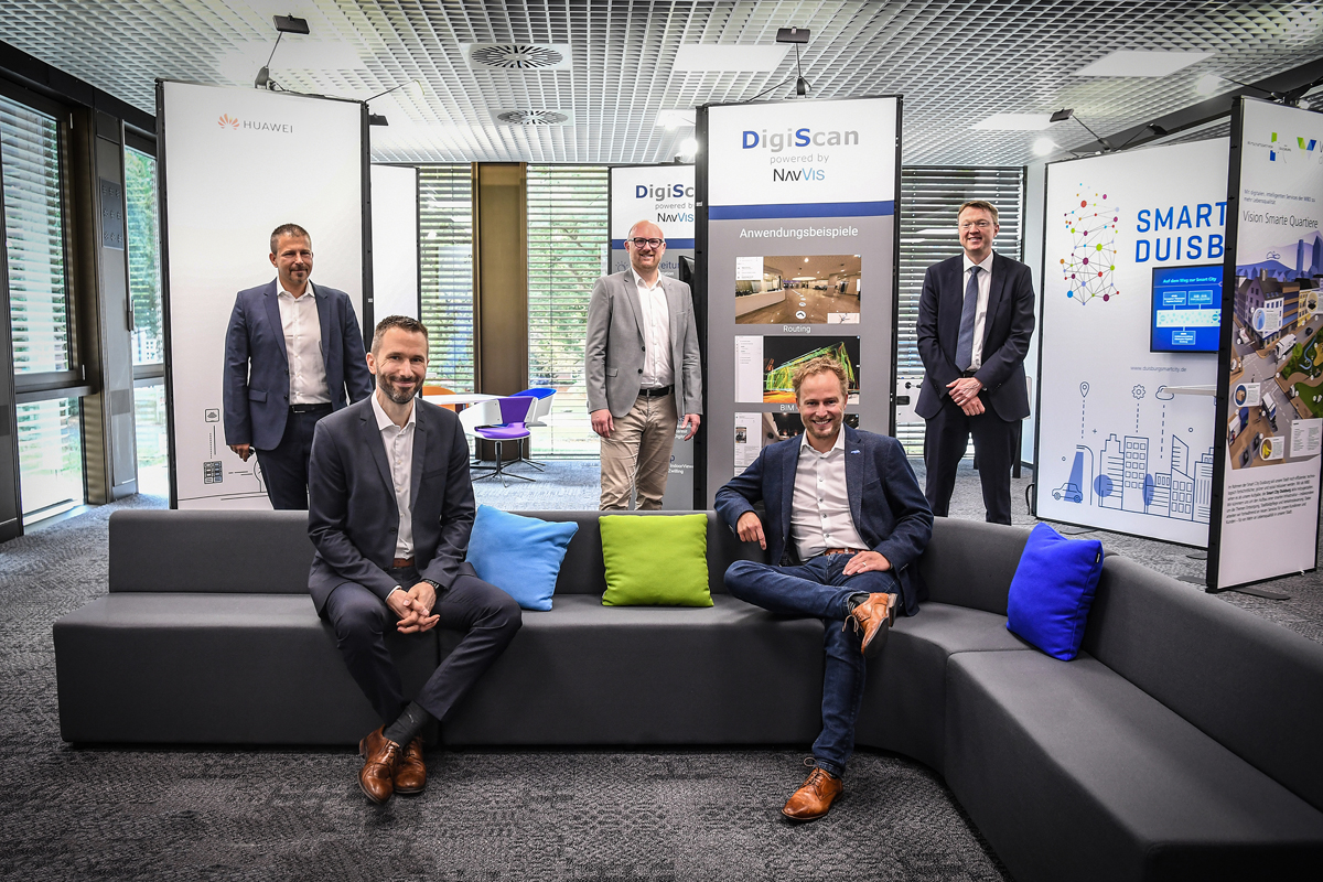 Zwei Personen sitzen auf einem Sofa, vier weitere stehen im Hintergrund bei der Eröffnung des Smart City Innovation Centers in Duisburg.