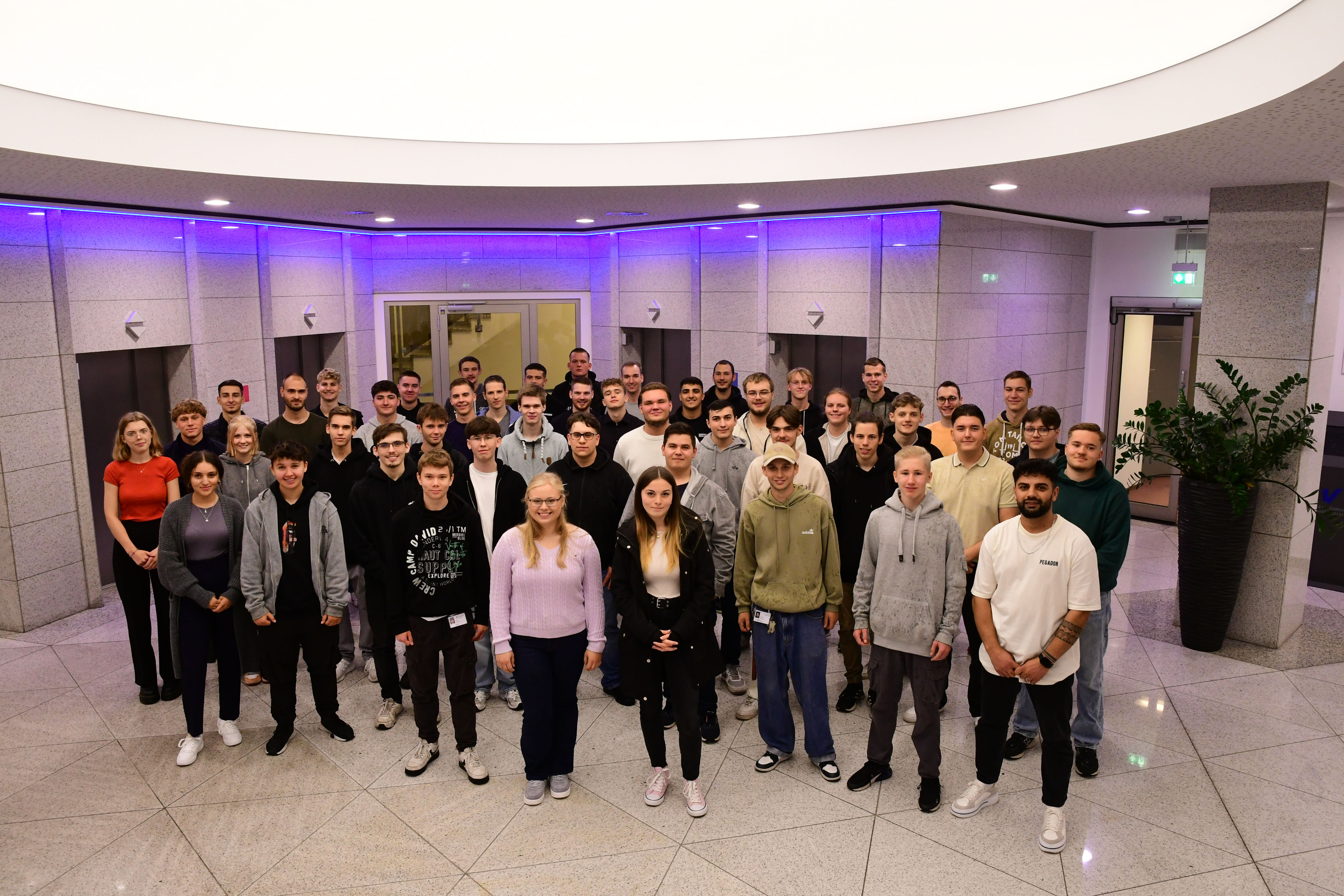 Gruppenfoto von 49 neuen Auszubildenden im Foyer des Verwaltungsgebäudes des DVV-Konzerns.
